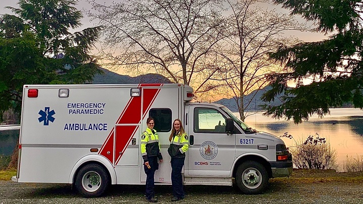 Paramedics Allison Stiglitz and Virginia Mountain in front of their ambulance at sunset in Tahsis