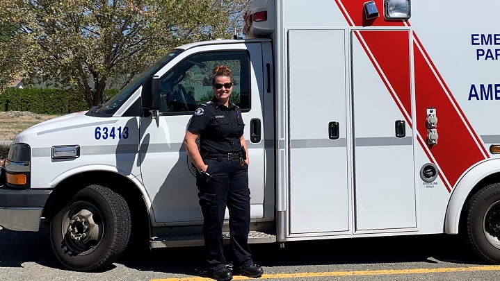 Paramedic Michelle Cowan stands in front of a BC Emergency Health Services ambulance