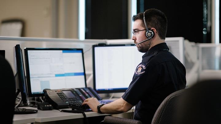 911 dispatcher with headset at a computer