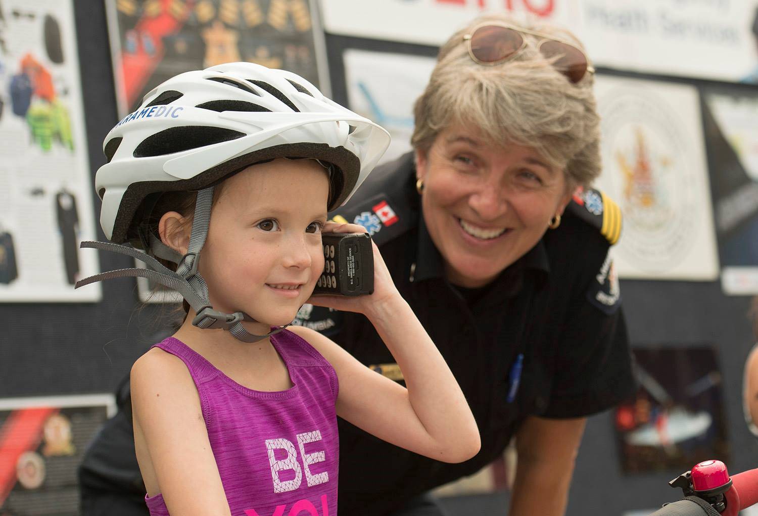 Paramedic unit chief Marilyn Oberg teaches a child about calling 9-1-1