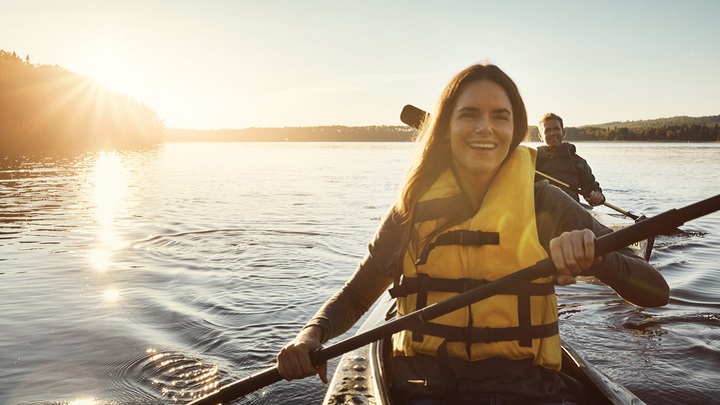 Couple kayaking with life jackets on
