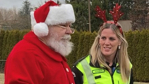 Santa Claus with paramedic Joanna Stefani, who is wearing a high visibility jacket and reindeer antlers