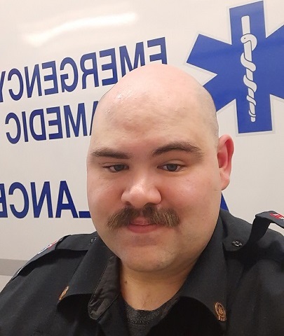 Paramedic Greg Trumbley next to an ambulance